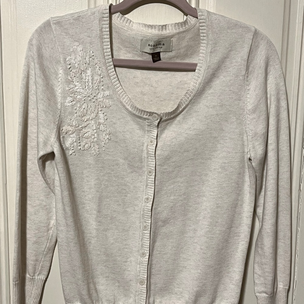 Cream sweater; long sleeves round neck line button down embroidery left front